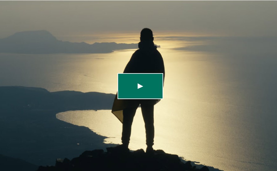 Man standing on mountain overlooking the sea