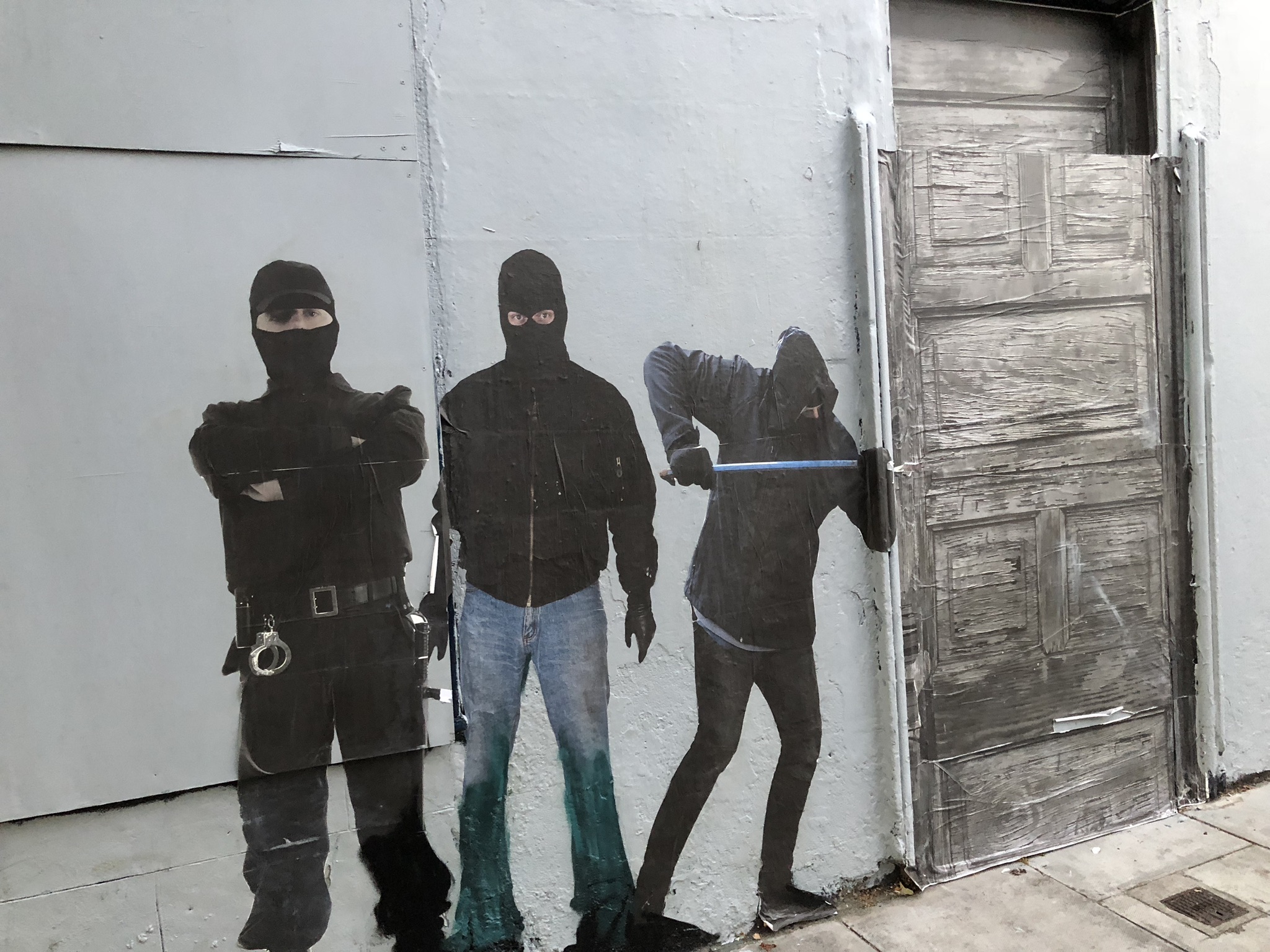 A painting showing 3 dodgy guys with balaclavas forcing .... a real door open!